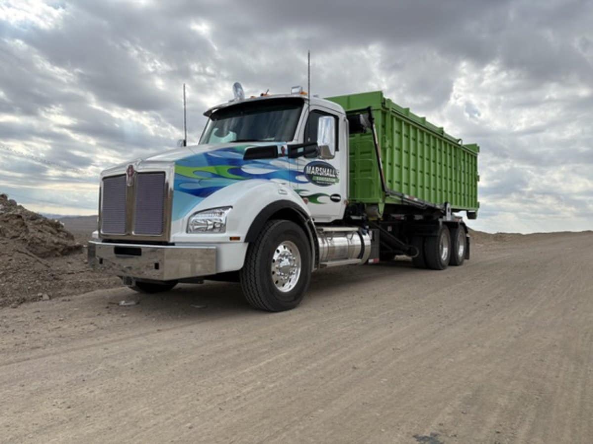Marshall's Kenworth roll-off truck with a green dumpster